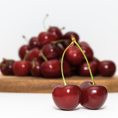 a pile of ripe red cherry berries lies on a wooden board background image on a white background without people close up