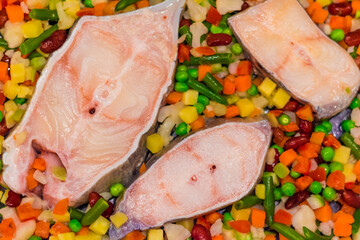 catfish fish with vegetables, peas, carrots, potatoes and corn. natural beautiful design, selective focus, diet concept and healthy right food, top view