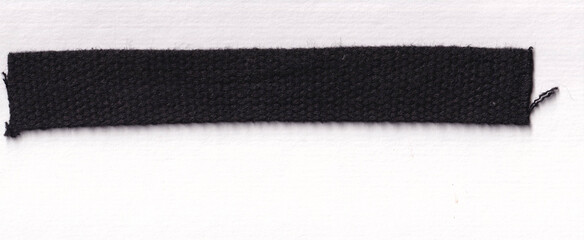 Closeup of a woven black fabric strip used in fashion and clothing