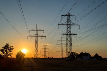 Fototapeta premium Starkstrommasten im Sonnenuntergang