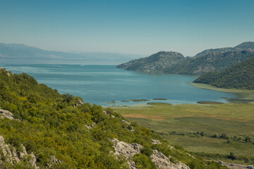 Fototapeta na wymiar Panoramic view at the Montenegrin part of Skadar lake with highway around. Crnojevica river landscape. Beautiful nature of Montenegro national parks.
