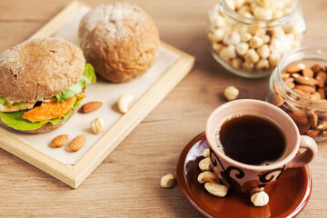 Obraz na płótnie Canvas Breakfast meal. Coffee cup, sandwich and nuts. Natural products.