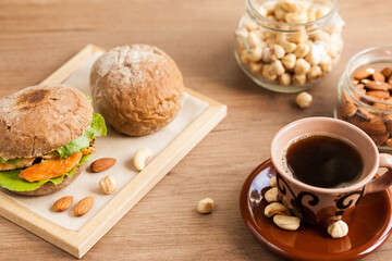 Breakfast meal. Coffee cup, sandwich and nuts. Natural products.