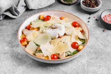 caesar salad with cheese and tomatoes and poached egg