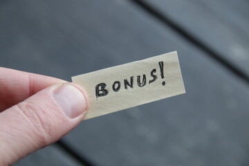 Win concept, hand holds label with inscription on vintage background.