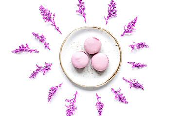 Trendy woman pattern with flowers and macaroons on plate top view