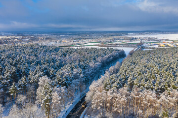 Aerial landscape of the road through snowy forest at winter, Poland.