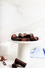 Glazed curds chocolate on white stand. Dessert chocolate with glazed cheese on marble background. 