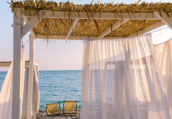 Beautiful canopies or baldachine at sea beach at the sunset. Vacation and relaxation concept. © Visual Intermezzo