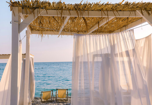 Beautiful canopies or baldachine at sea beach at the sunset. Vacation and relaxation concept.