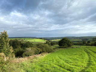Fototapeta na wymiar Landscape, with lush meadows, fields, and distant hills, on a cloudy day near, Kennel Lane, Sowerby Bridge, UK