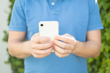 Close up of Man’s Hands of young man using his phone.