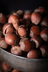A shelled hazelnut in a bowl among freshly shelled hazelnuts. Close up.