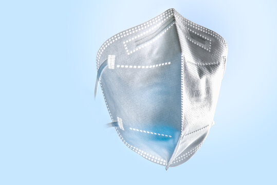 FFP2 Maske , Gesichtsmaske für Eigenschutz und Schutz Anderer, freigestellt, blau angestrahlt mit Textfreiraum.