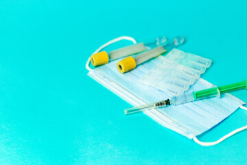 Medical vials for injection, syringe for injection, mask gloves on a blue background. Admission vaccination, flu shot.