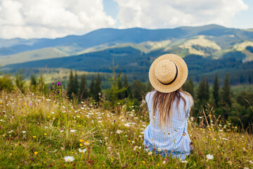 Traveling in spring Ukraine. Trip to Carpathian mountains. Woman tourist relaxing in flowers...