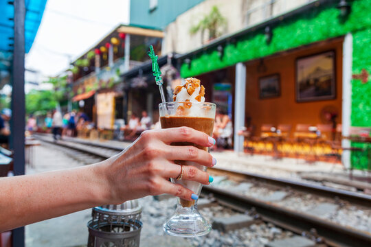 traditional vietnamese egg coffee in a cup, a glass of coffee in the female hand