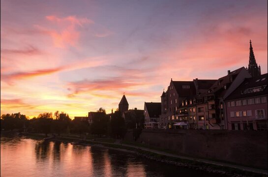 An autumn sunset video taken on a bridge over the Danube river, the famous tower of Ulm Minster also visible