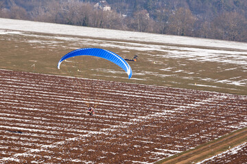 Extreme sports pilot flying with a paramotor engine and a paraglider prepares to land on the ulm runway