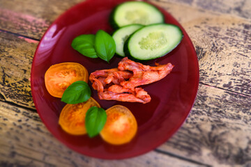partial blurred BBQ chicken wings with spices, vegetables and basil
