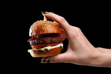 female hand holding mini burger as a Christmas tree toy on black background