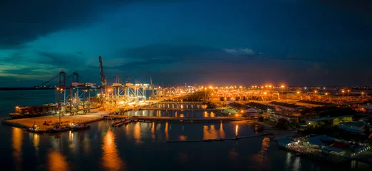 Foto op Plexiglas An aerial view at night of a busy port with ship waiting to be filled with containers. © MohdFaizalAzri