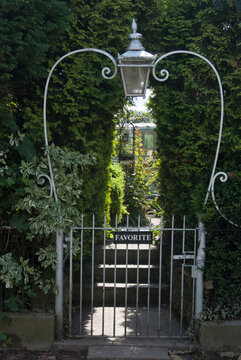 Heart shaped gates, with a lamp at the top, leading to a garden.