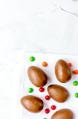 Easter chocolate eggs top view on stone background mock up