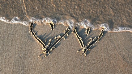 Heart Shapes Being Drawn on Sandy Beach and Wiped Out by Sea Wave at Sunset
