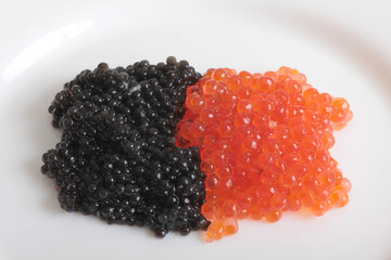 Red caviar lies in a glass bowl. Isolated object on a white background