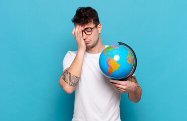 young man feeling bored, frustrated and sleepy after a tiresome, dull and tedious task, holding...