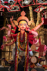 Obraz premium Idol of Goddess Devi Durga at a decorated puja pandal in Kolkata, West Bengal, India. Durga Puja is a popular and major religious festival of Hinduism that is celebrated throughout the world.