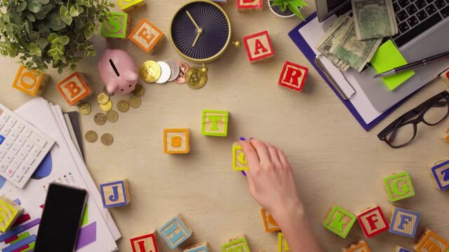 Woman hand arranging wooden cubes with word STOCK top view