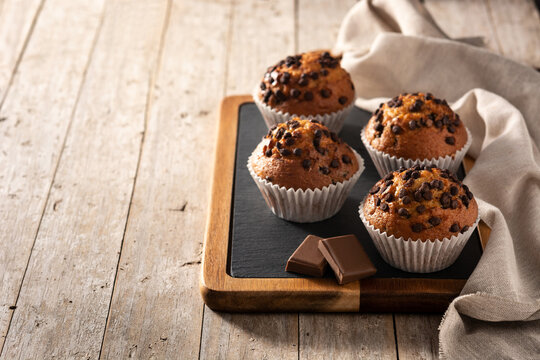 Just baked chocolate muffins on wooden table. Copy space
