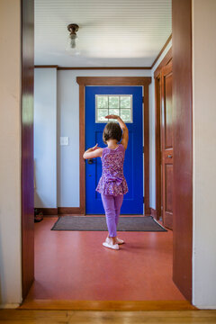 A Small Girl In A Sparkly Ballet Costume Dances In Her Front Entryway
