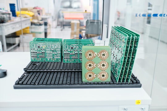 66/5000 motherboard placed on a stand above a table in a workshop