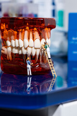 Perfect smile, perfect teeth, professional dental treatment. Dental whitening cleaning the mouth. Small miniatures of workers and painters clean the mouth of dirt and make the teeth shine