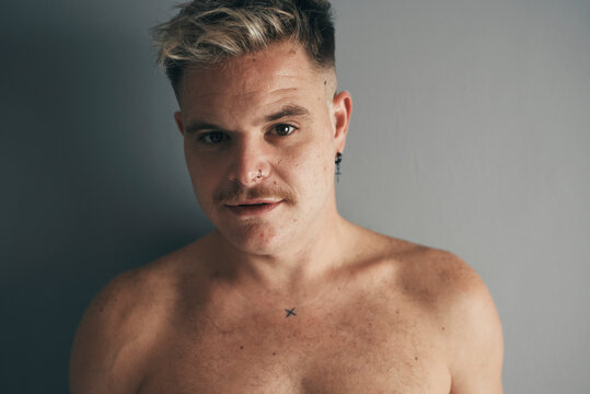 Portrait of a blond boy with a moustache and piercing
