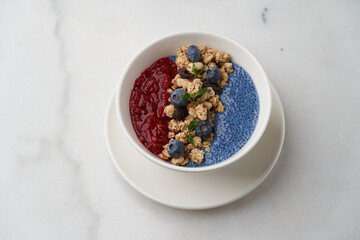 Breakfast smoothie bowl with granola on white background