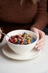 Breakfast smoothie bowl with granola on white background