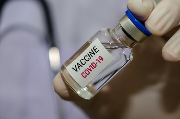 Male doctor holding a bottle of COVID-19 vaccine medicine Or the coronavirus vaccine