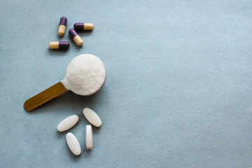 Three types of collagen in powder, tablets and capsules on a gray background. Measuring spoon with powdered hydrolyzed fish collagen. Supplements for beauty. Horizontal banner with space for text.