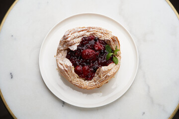 Puff pastry cake with berries on wooden background.