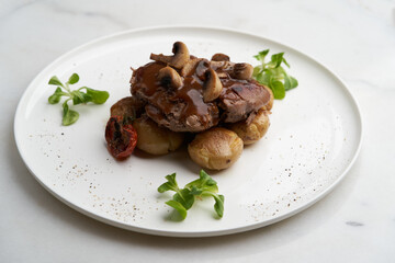 Beef stew with potatoes and mushroom on white plate