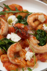 Gnocchi with shrimp and baked tomatoes. Italian seafood