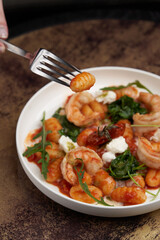 Gnocchi with shrimp and baked tomatoes. Italian seafood