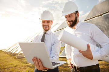 Positive engineers discussing project of solar power station