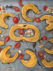 Roasted pumpkin slices with cherry tomatoes and seeds