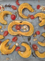 Roasted pumpkin slices with cherry tomatoes and seeds