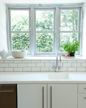 Kitchen windowsill with view to garden in cottage interior, UK.